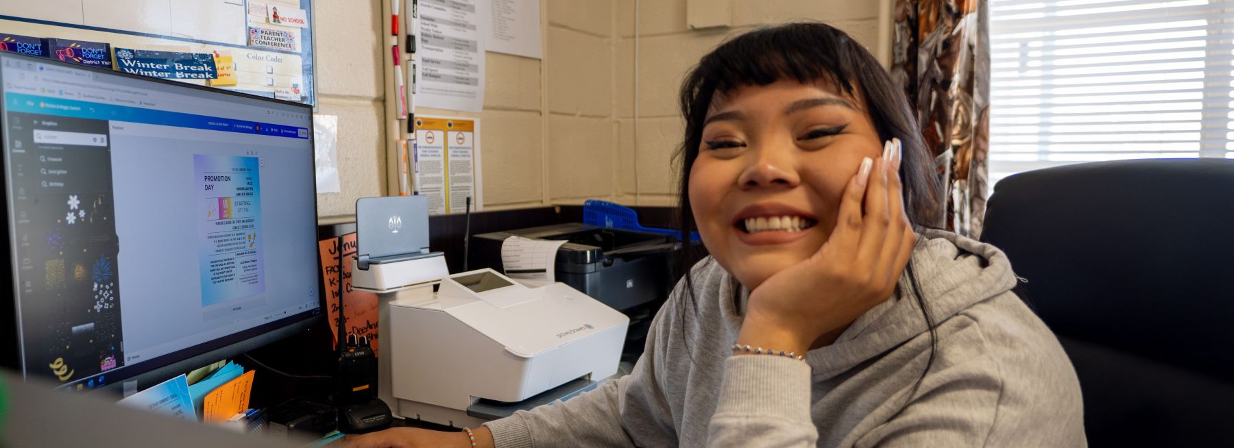 Happy student smiling at the camera in front of computer.