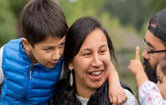 Mother and son smiling at daughter and father. 